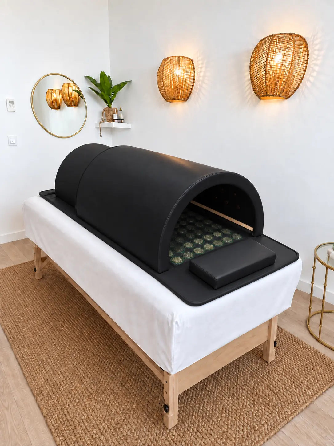Sauna japonais infrarouge Haruki Dôme noir posé sur une table de soin, ouvert sur le tapis de pierres de jade