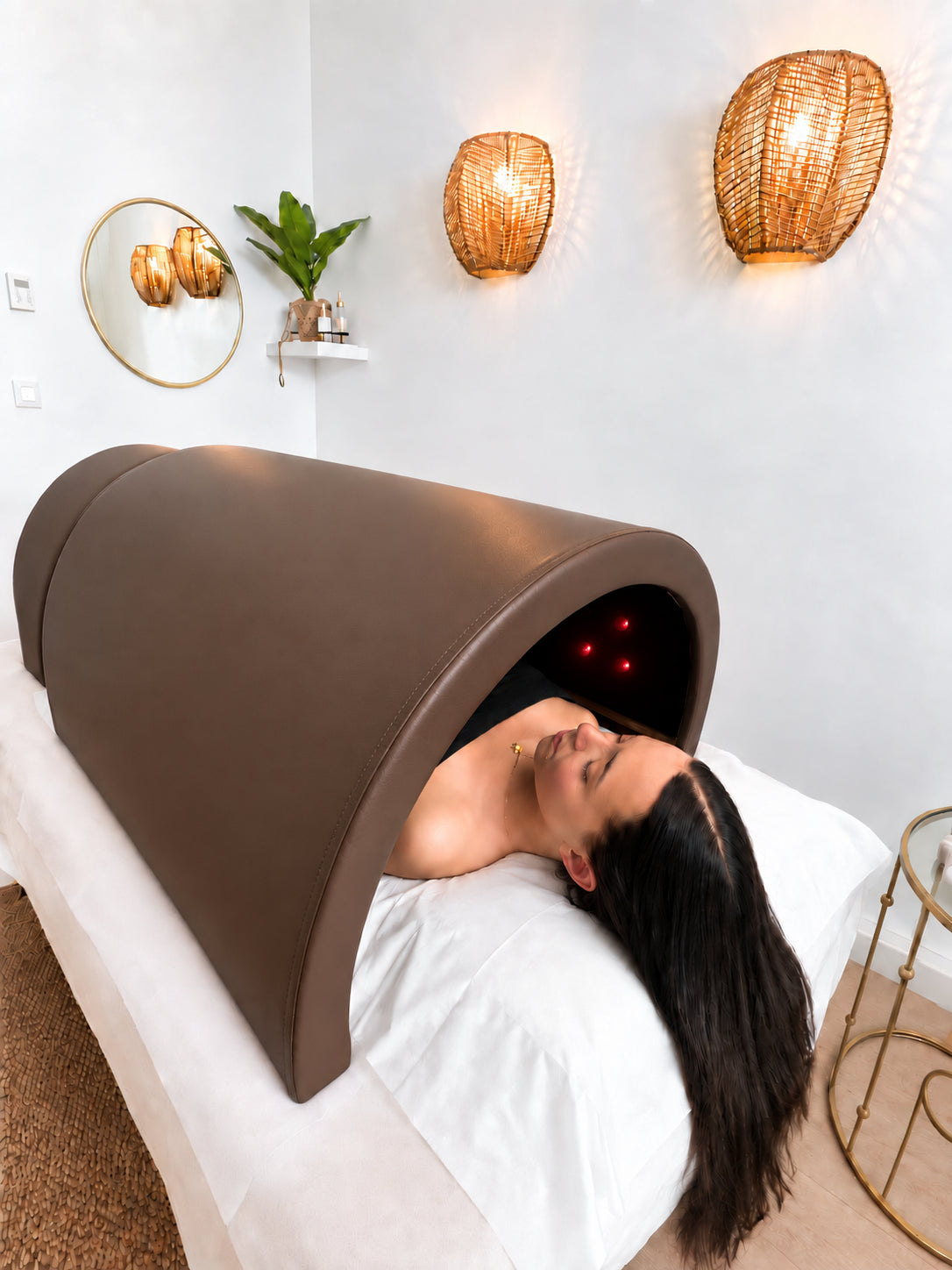 Cliente détendue sous le sauna japonais infrarouge Haruki Dôme marron, la tête à l'extérieur sur la table de soin